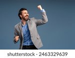 Happy successful gesturing businessman, isolated on blue background, celebrating. Copy space. Success, career, business concept