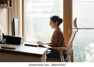 Happy Successful Millennial Indian Ethnic Business Lady Working In Modern Home Office, Using Computer Software Applications, Creating New Internet Project, Communicating Distantly With Client.