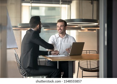 Happy successful multiracial businessmen handshake greeting or get acquainted at office meeting, smiling diverse male colleagues or partners shake hands closing deal after successful negotiation - Shutterstock ID 1548555857