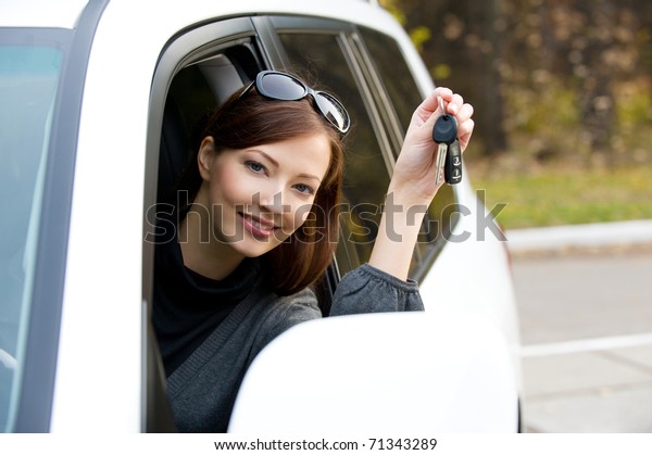 Happy successful woman with keys from the new\
car - outdoors