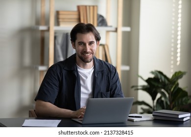 Happy Successful Young Business Professional Man In Casual Typing On Laptop, Working In Home Office, Looking At Camera, Smiling. Millennial Businessman, Freelance Employee Head Shot Portrait