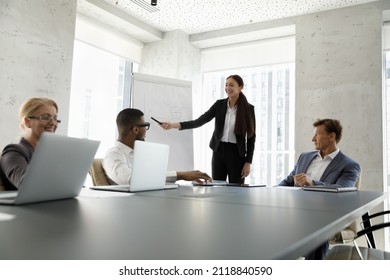 Happy Successful Young Female Manager Presenting Report To Diverse Business Team. Corporate Teacher, Representative Explaining Marketing Strategy, Sales Data To Employees On Training Meeting