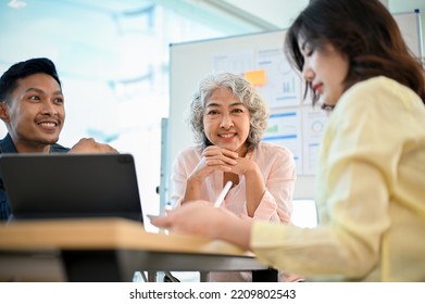 Happy And Successful-aged Asian Female Boss Or Executive Manager In The Meeting With Her Marketing Team.