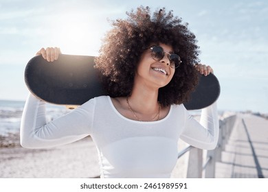 Happy, summer and black woman by sea with skateboard for weekend, holiday and vacation in style. Fashion, laughing and person skateboarding for activity, freedom and adventure by ocean or seaside - Powered by Shutterstock