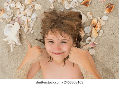 Happy Summer vacation. Cute blonde child relax on sand. Child play with Sea shells and fine beach sand. Kid laying on sandy beach with Shells. Summer kids face. - Powered by Shutterstock