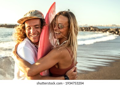 Happy surfer couple with surfboard having fun on the beach, smiling, spending time together. Sporty people. Real people emotions. Extreme surfing sport and youth relationship lifestyle concept - Powered by Shutterstock