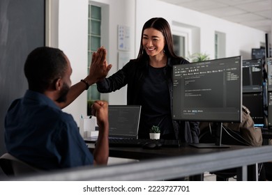 Happy system engineers celebrating successful code script compiling, doing highfive hand gesture after system development. Team of web developers analyzing algorithm and creating app server interface.