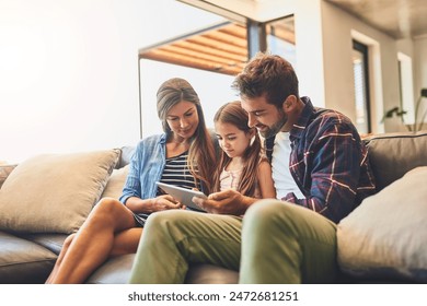 Happy, tablet and family hug on sofa with child, education for development and elearning. Love, girl and browsing on touchscreen for digital app game, website for streaming movie and learning online - Powered by Shutterstock