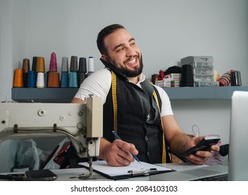 Happy Tailor Shop Owner Checking Monthly Reports, Bills And Expenses Of His Small Business.  Small Entrepreneurship