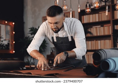 Happy Tailor working with skin textile in workshop. Shoemaker cobbler use natural brown leather. - Powered by Shutterstock