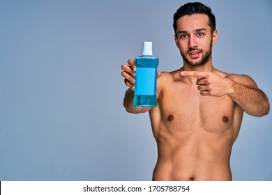 Happy Tanned Man Point On Dental Rinse Aid In Hand