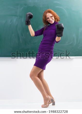 Happy teacher in boxing gloves celebrating her victory