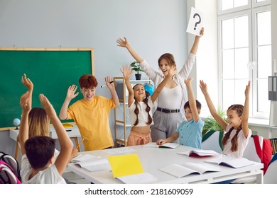 Happy teacher and children having fun in class. Cheerful woman and joyful students play games in the classroom, write in notebooks, answer questions and solve problems together. Back to school concept - Powered by Shutterstock