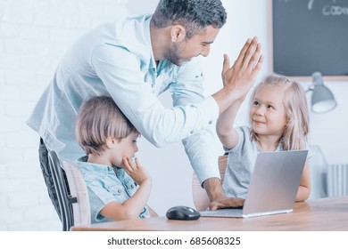 Happy teacher congratulates girl in the task of programming during coding classes