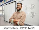 Happy teacher explaining mathematics at whiteboard in classroom. Portrait of smiling mathematics tutor explaining addition concept to children in classroom. Successful teacher standing in classroom.