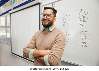 Happy teacher explaining mathematics at whiteboard in classroom. Portrait of smiling mathematics tutor explaining addition concept to children in classroom. Successful teacher standing in classroom.