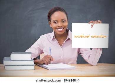 Happy teacher holding page showing vocational education in her classroom at school
