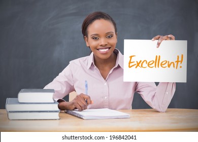 Happy Teacher Holding Page Showing Excellent In Her Classroom At School