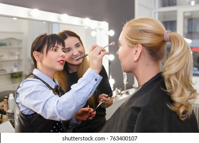 Happy Teacher Visagiste With Her Student Girl Applying Makeup On The Eyes At Master Class In Beauty School