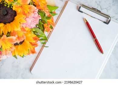 Happy Teachers Day, boss day concept card and bouquet.Bouquet of beautiful fresh flowers with clipboard and pen on white background. Floral mock up for greeting card.Education knowledge day concept - Shutterstock ID 2198620427