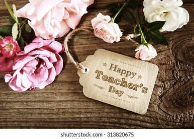 Happy Teachers Day message card with small roses on wood background - Shutterstock ID 313820675