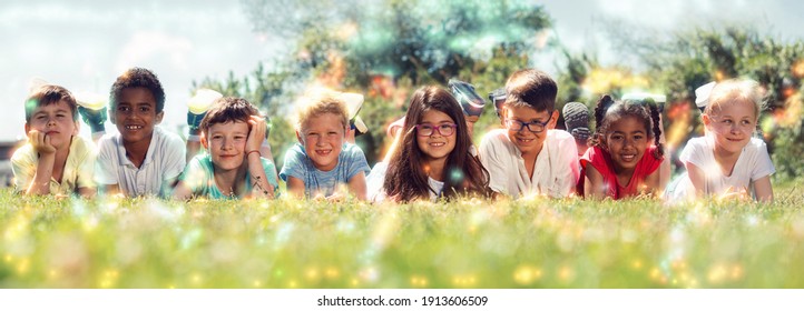 Happy team of friends children resting on grass together in park