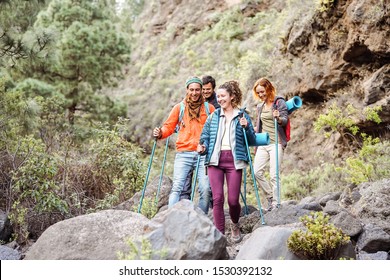 Happy team friends doing trekking excursion on mountains - Group young tourists hiking and exploring the wild nature - Trekker, hike sport and travel people concept - Shutterstock ID 1530392132