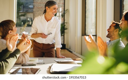 Happy Team Members Applauding Mentor For Her Guidance In Strategy Planning. Happy Female Sharing Success Of Startup In Meeting