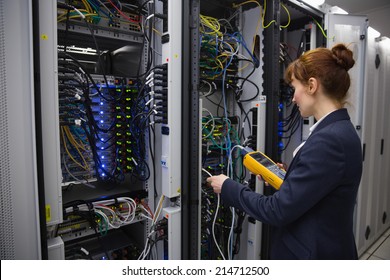 Happy technician using digital cable analyzer on server in large data center - Powered by Shutterstock