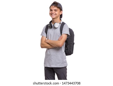 Happy teen boy in cap with headphones and backpack, isolated on white background. Smiling child with folded arms looking at camera. Emotional portrait of handsome teenager guy Back to school. - Powered by Shutterstock