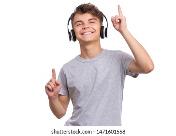 Happy Teen Boy With Headphones, Isolated On White Background. Cheerful Child Listening To Music, Singing Song And Dancing. Emotional Portrait Of Handsome Teenager Guy Enjoying Music.