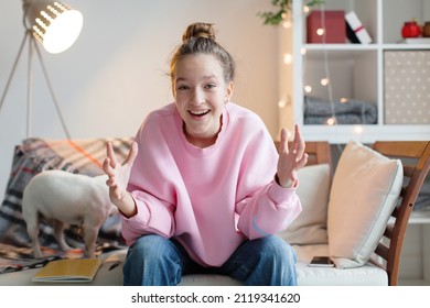 Happy teen girl blogger talking to camera video calling, recording vlog. Happy young woman laughing distance chatting at home. Funny social media influencer streaming. Webcam view