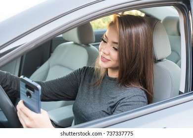 Happy Teen Girl Driving A New Car While Texting