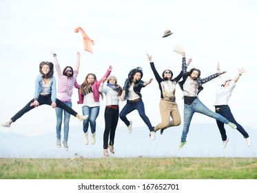 Happy teen girls having good fun time outdoors jumping up in air