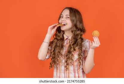 Happy Teen Kid Biting Oatmeal Cookies On Orange Background