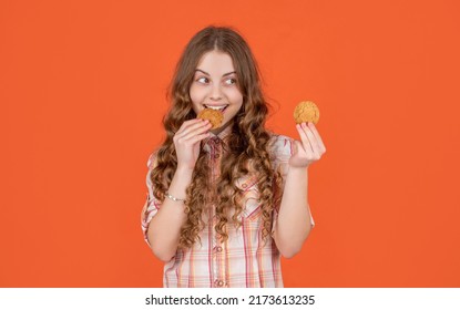 Happy Teen Kid Eating Oatmeal Cookies On Orange Background