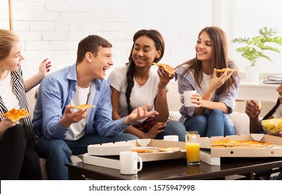 Happy Teen Roommates Eating Pizza And Chatting, Having Small Party At Home