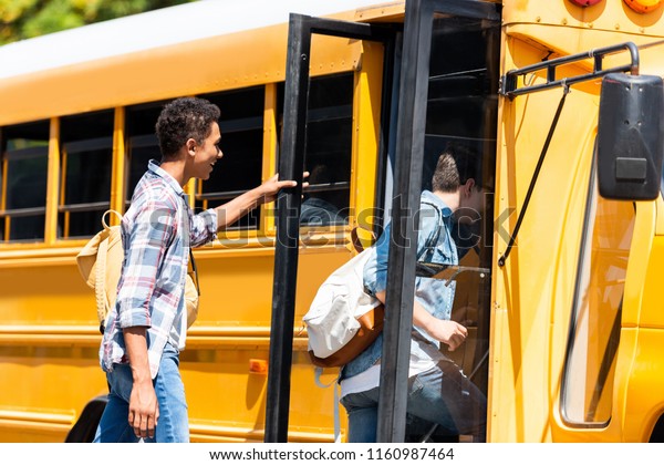happy teen\
schoolboys walking at school\
bus