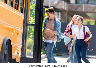 Happy Teen Students Running Into School Bus