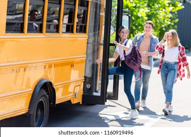 Happy Teen Students Walking Into School Bus