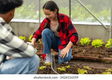 Happy teenage boy and girl growing organic vegetable on agriculture farm field in greenhouse garden. Diversity young people student learning nature and gardening healthy food for sustainable living. - Powered by Shutterstock