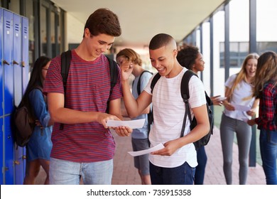 Happy Teenage Boys Sharing Exam Results In School Corridor