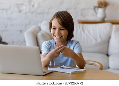 Happy Teenage Child Boy Looking At Computer Screen, Making Gestures, Using Sign Language Communicating Online By Video Call With Professional Speech Therapist, Learning Remotely Alone At Home.