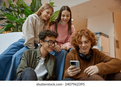 Happy teenage friends watching funny video on smartphone at shopping mall - Powered by Shutterstock