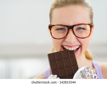 Happy Teenage Girl Eating Chocolate Bar