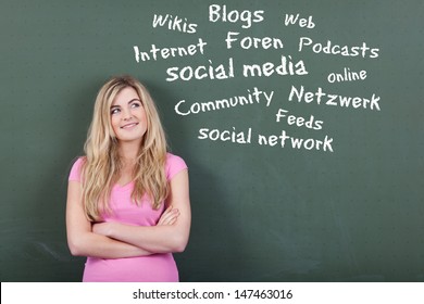 Happy Teenage Girl Looking At Collection Of Social Media And Networking Related Words On Blackboard