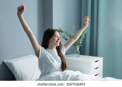  Happy Teenage Girl Meets A New Day In A Beautiful Room. A Beautiful Teenager Wakes Up In The Morning, Stretches In Bed, Bright Light On Her From A Large Window. 