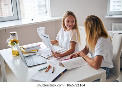 Happy Teenage Girl Proudly Demonstrating The Copy With A Right Answer To Her Parent While Studying Her Lessons