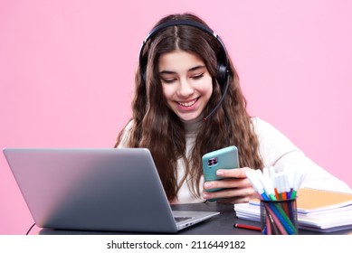 Happy Teenage Girl Using Her Cellphone During An Online Class, Slacking And Not Paying Attention