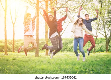 Happy Teenage Group Jumping Outside